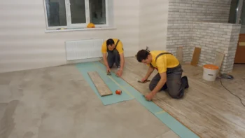 Builders laying wooden flooring