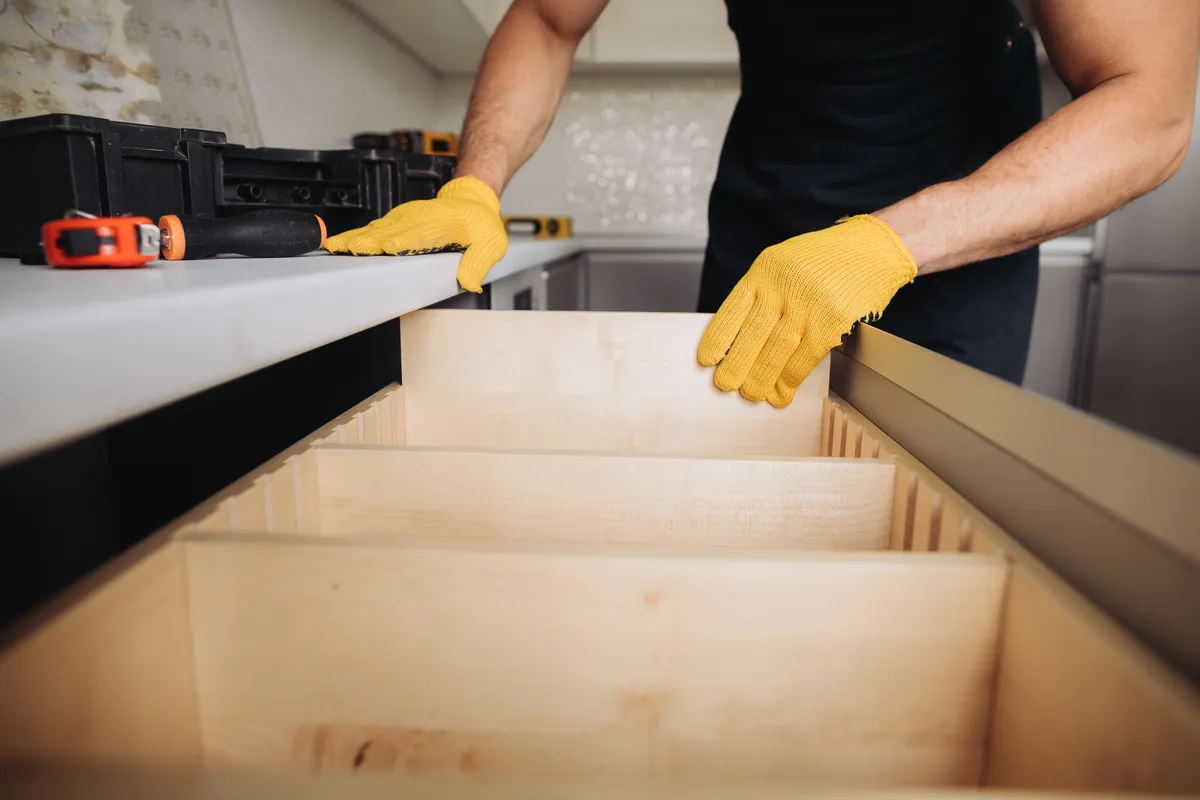 Maintenance man installing kitchen furniture